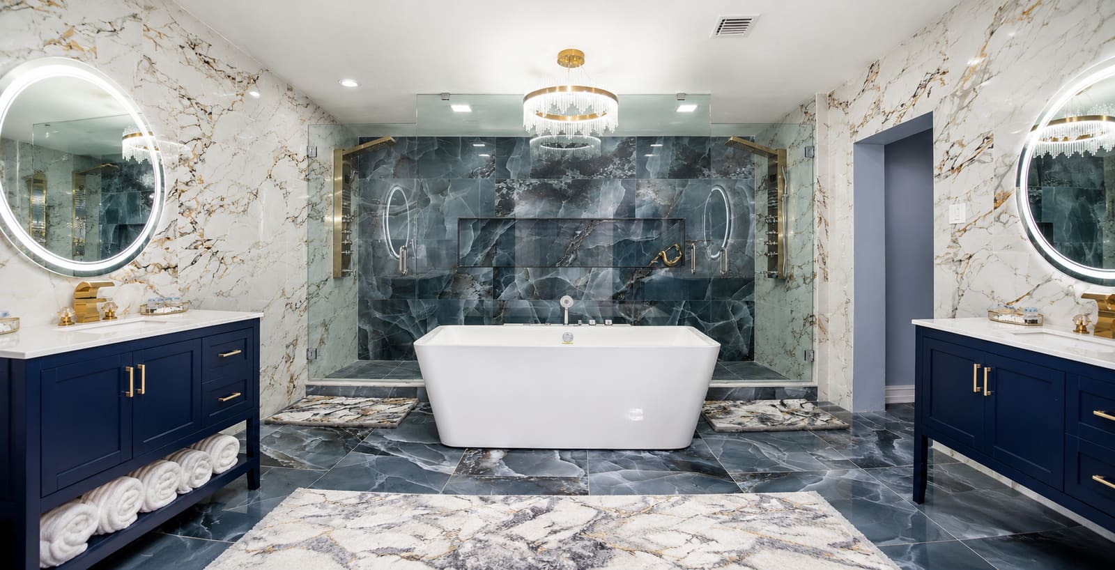 Finished luxury bathroom remodel with navy vanities and dark marble shower — REV Home Solutions