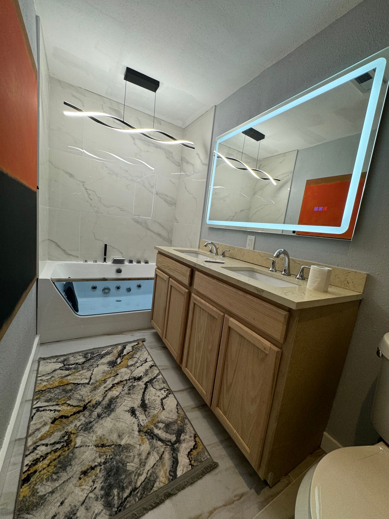 Finished bathroom remodel with jetted tub, marble tile and oak double vanity — REV Home Solutions