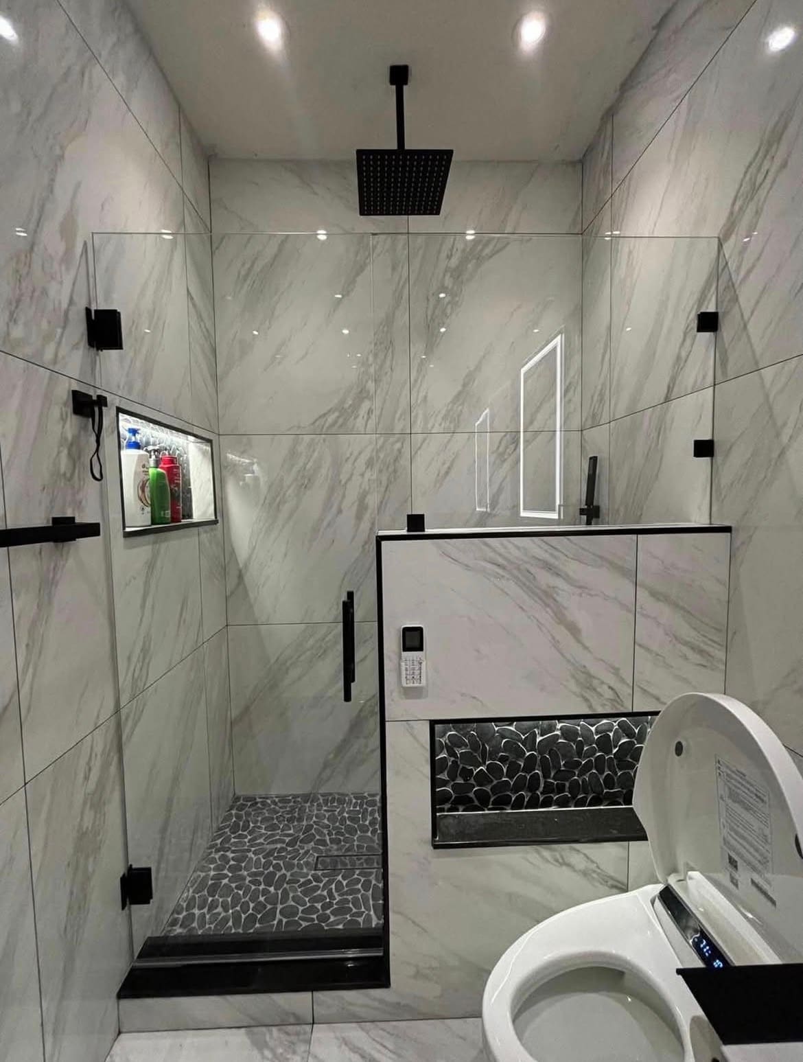 Finished bathroom remodel with custom marble-tile shower — REV Home Solutions