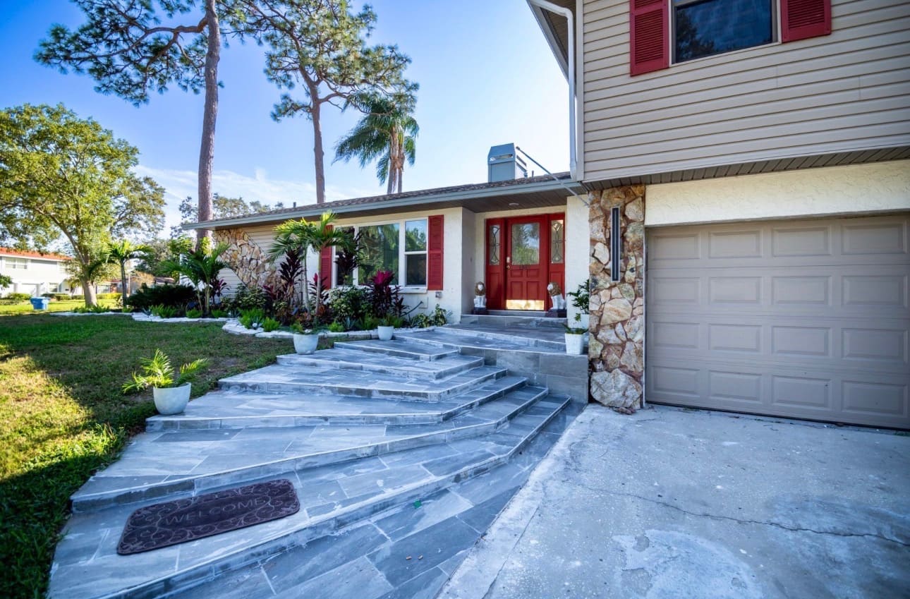 Finished home exterior with custom stone steps and walkway — REV Home Solutions