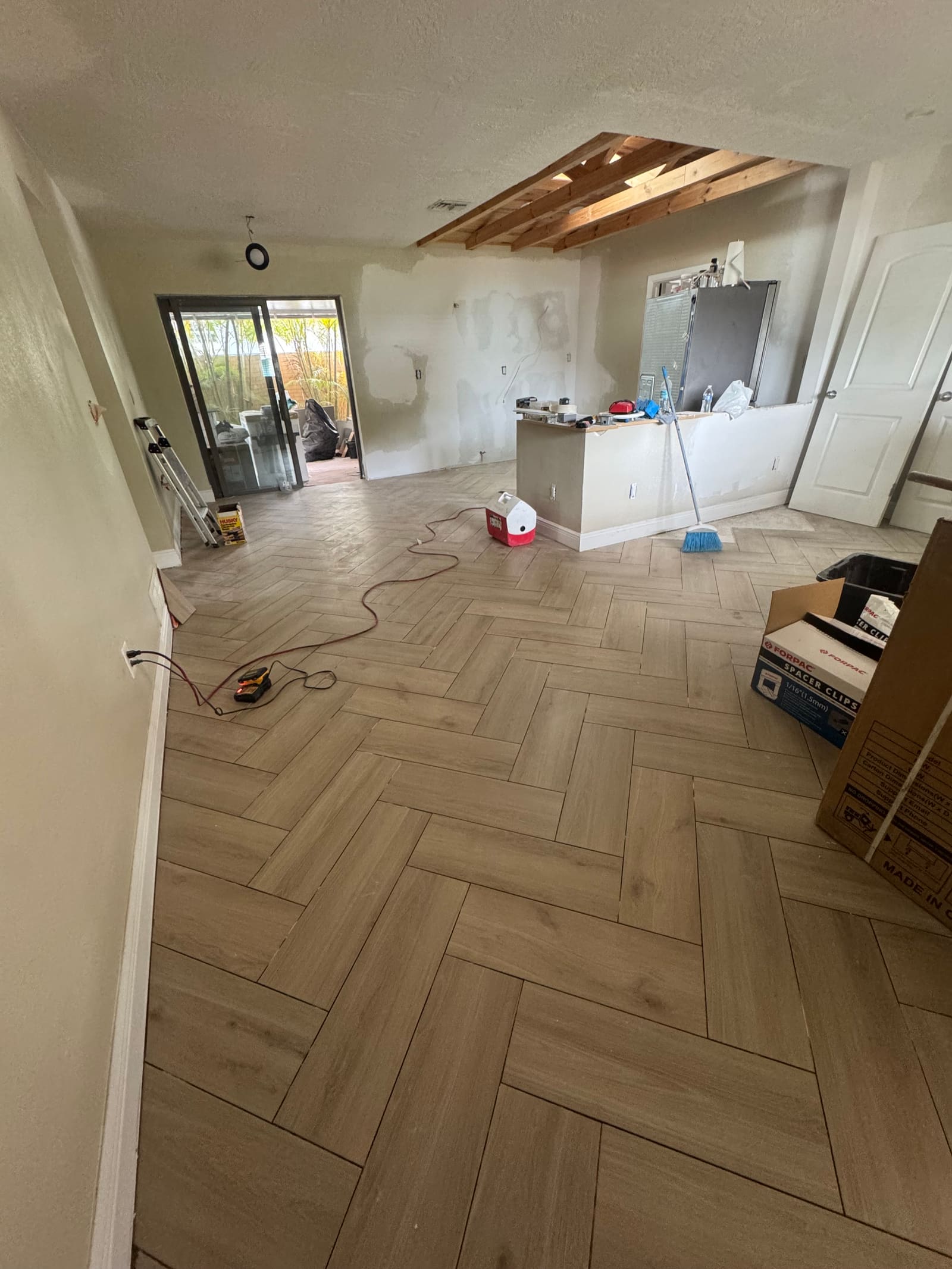 Finished herringbone wood-look tile flooring installation — REV Home Solutions