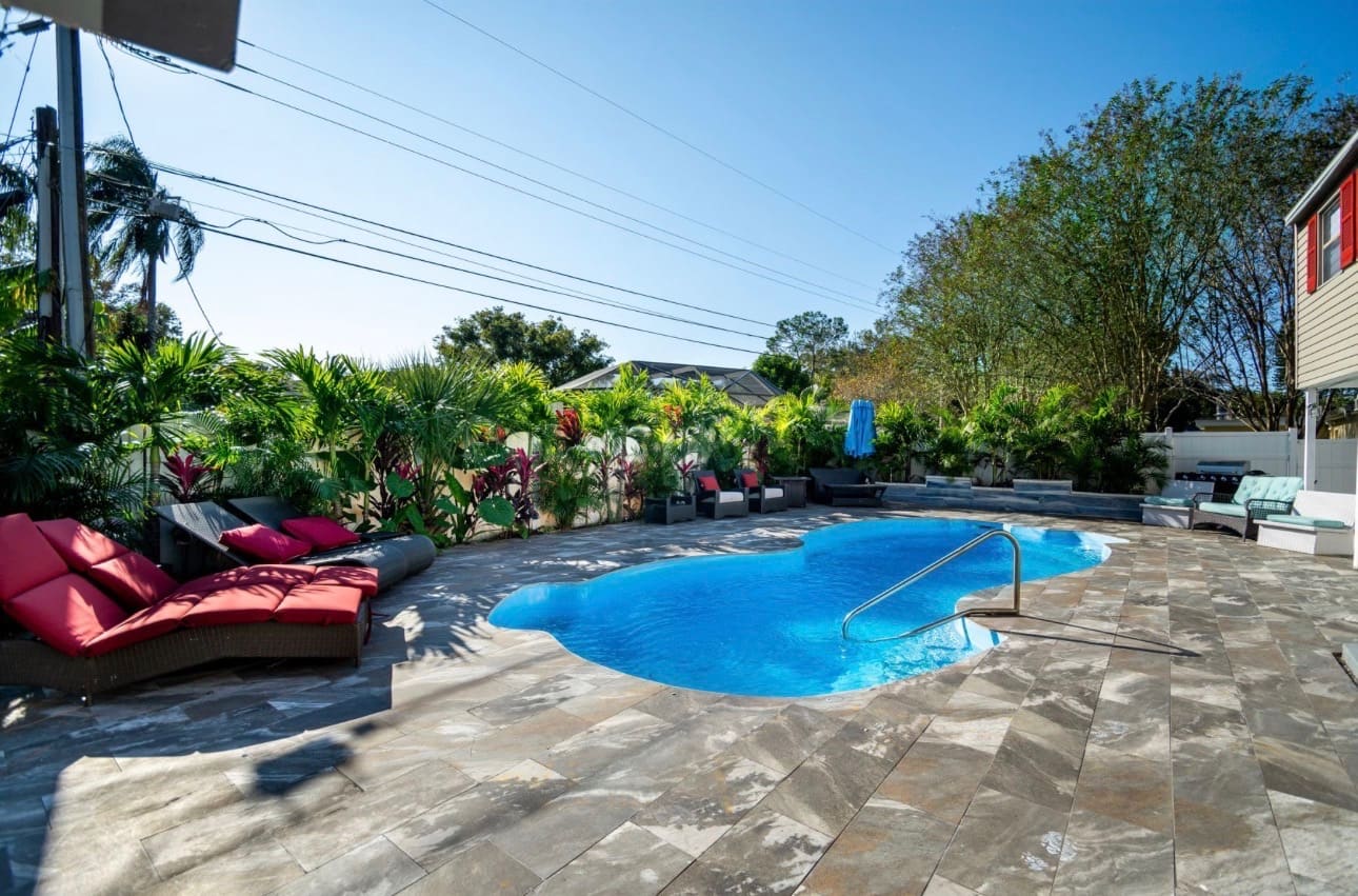Finished outdoor stone paver flooring installation around a pool patio — REV Home Solutions