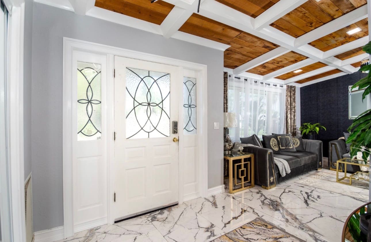 Finished entryway with custom leaded-glass door and marble flooring — REV Home Solutions