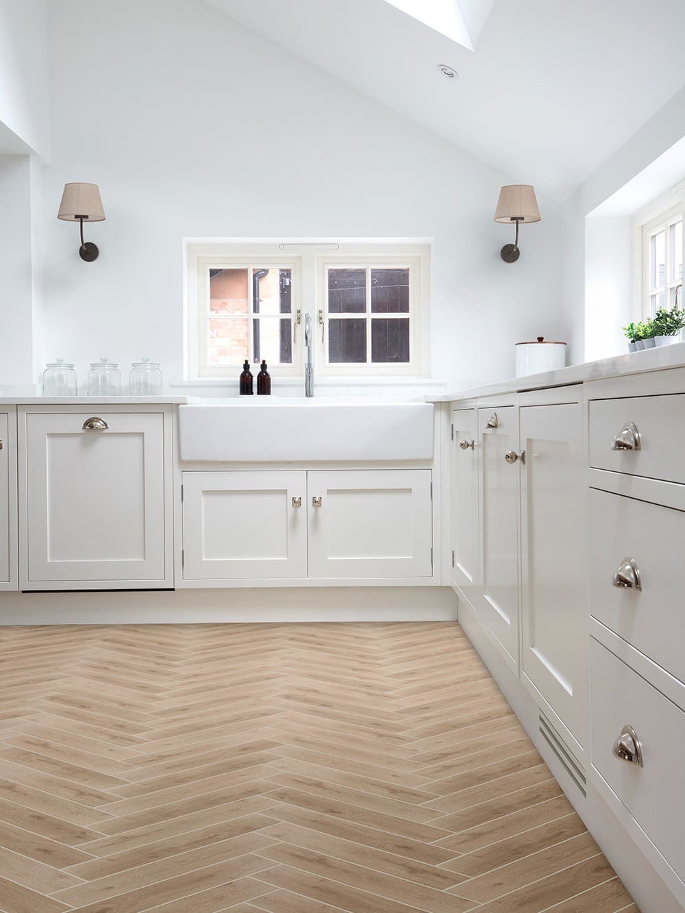 Finished kitchen remodel with white shaker cabinetry and herringbone tile flooring — REV Home Solutions