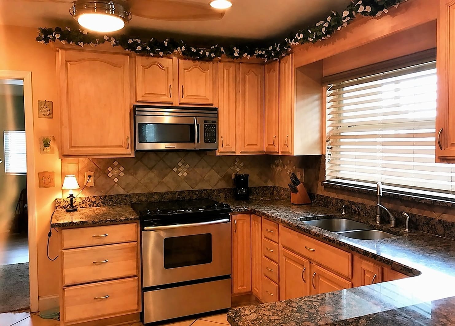 Kitchen before remodel — dated tan cabinetry and granite countertops