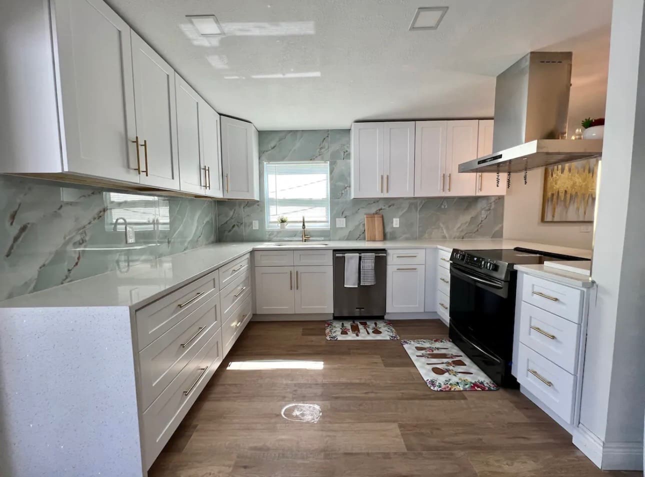 Finished kitchen remodel with white shaker cabinetry and marble-look backsplash — REV Home Solutions