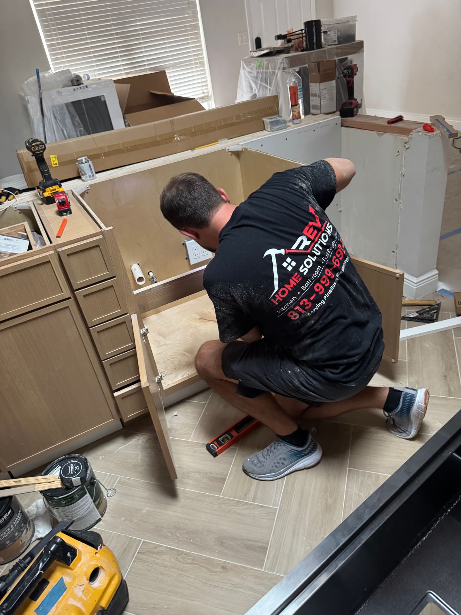 REV Home Solutions team member installing kitchen cabinetry